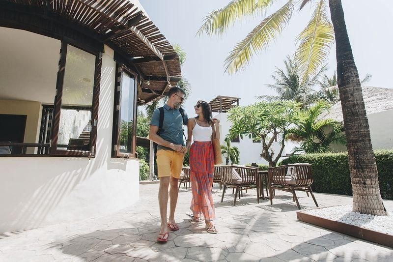 Figure 4 (left): a couple walking hand in hand at a tropical resort.